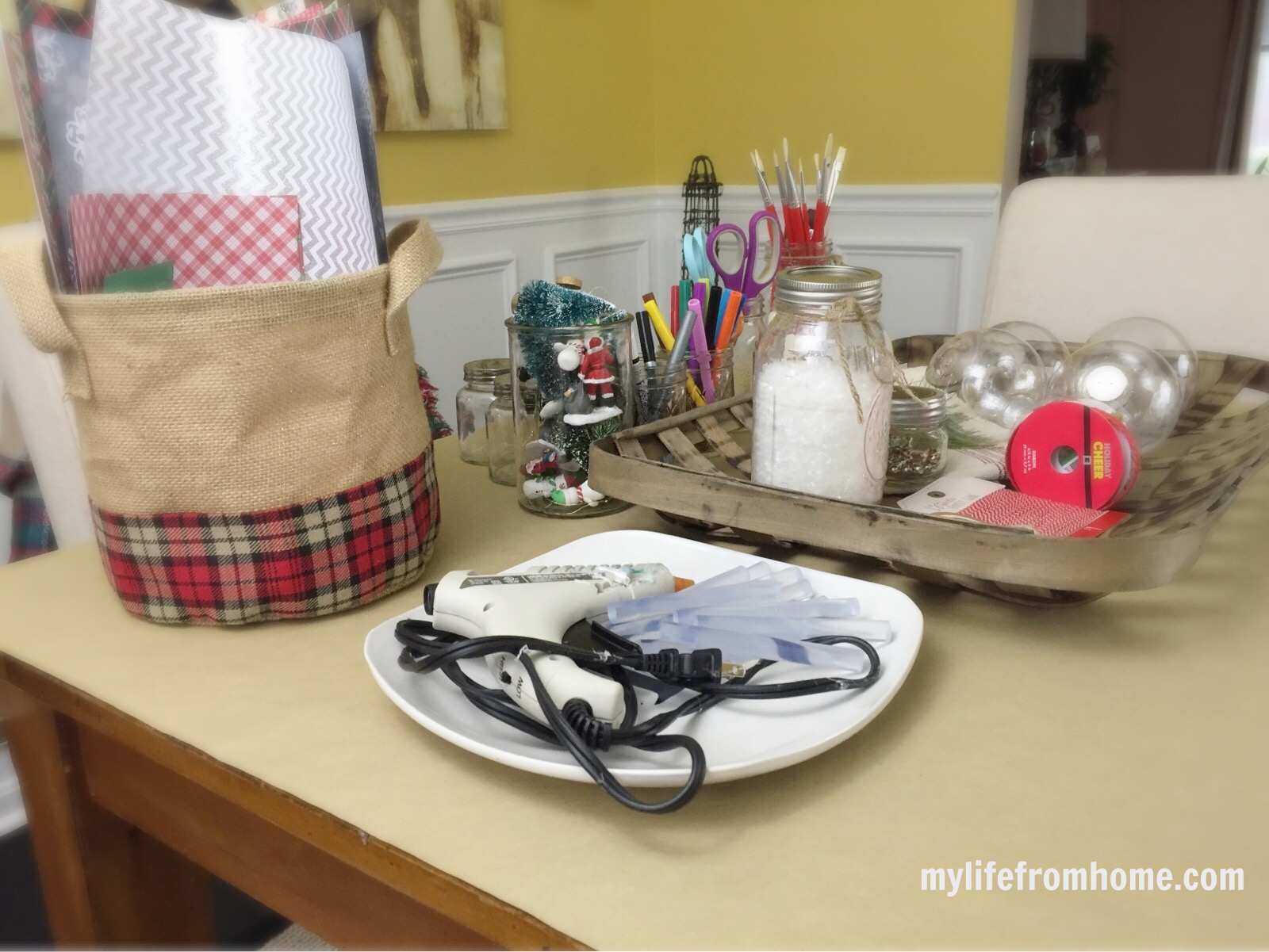 Paint pens and craft tools organised in jars on a festive worktable