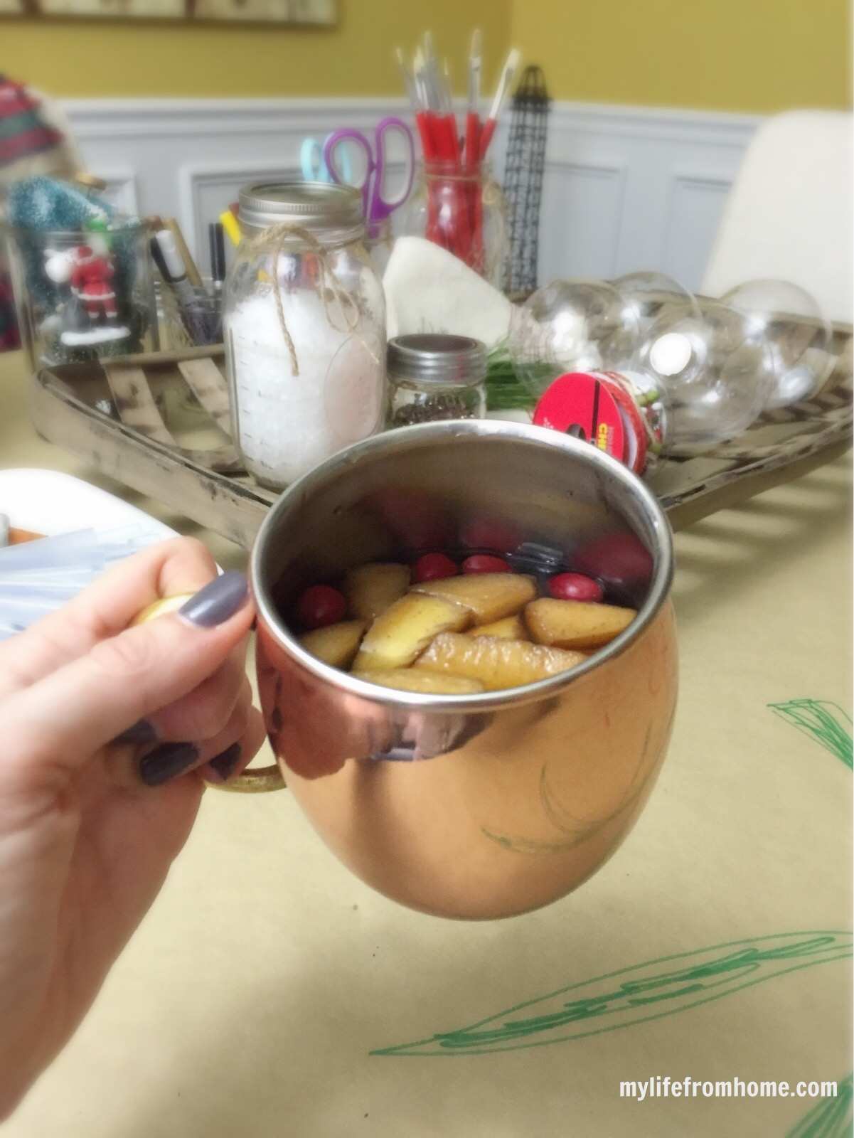 Copper mug filled with warm fruit-infused tea at a Christmas party