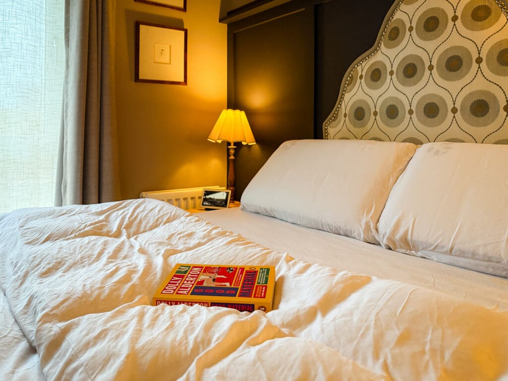 Good Material by Dolly Alderton book on a white bed with soft lighting